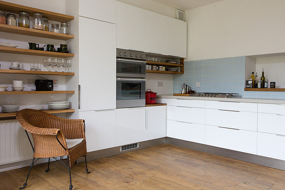 A nice combination of open shelving and sleek white cabinets in the kitchen